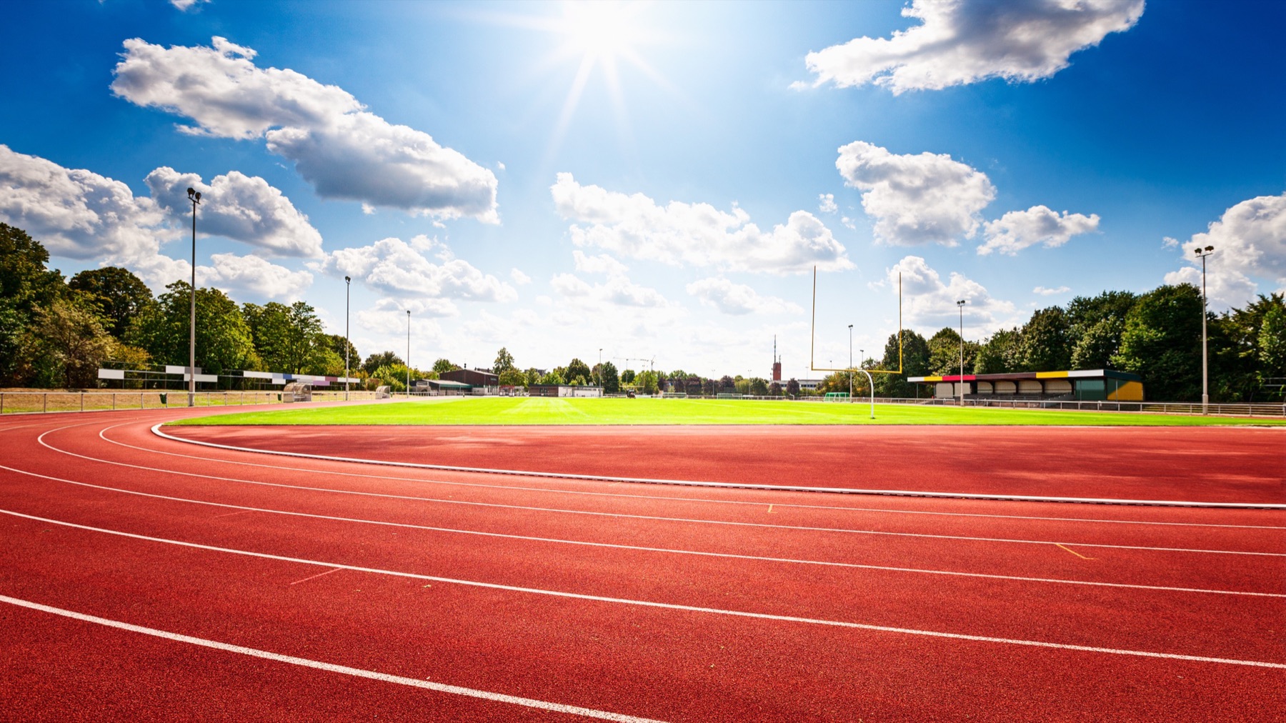 Sunny running track and field under a bright blue sky
